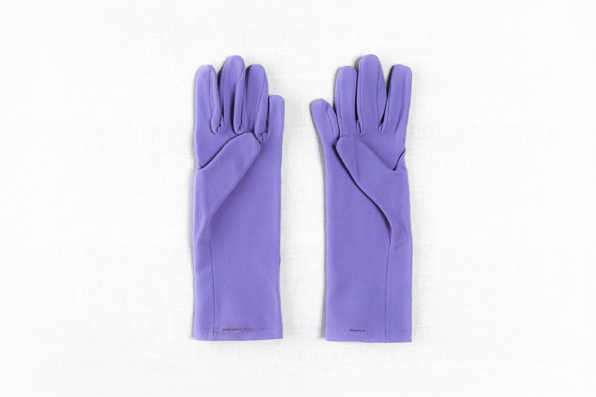 Pair of purple gloves on a white background Pair of lavender womens gardening gloves with smooth palm on a white background