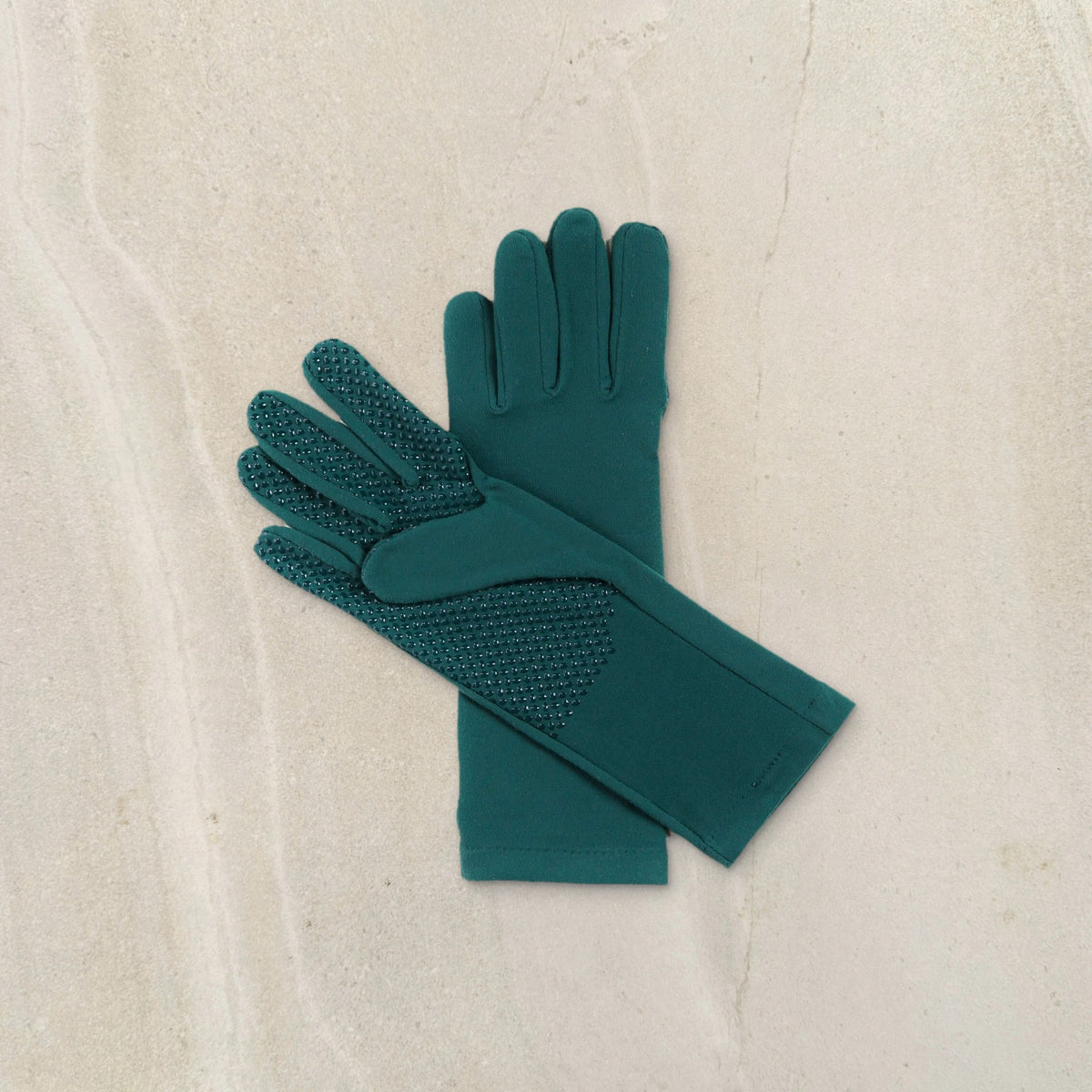 higarden mid rise gardening gloves in ferngully green showing the grip palm, flat lay on limestone