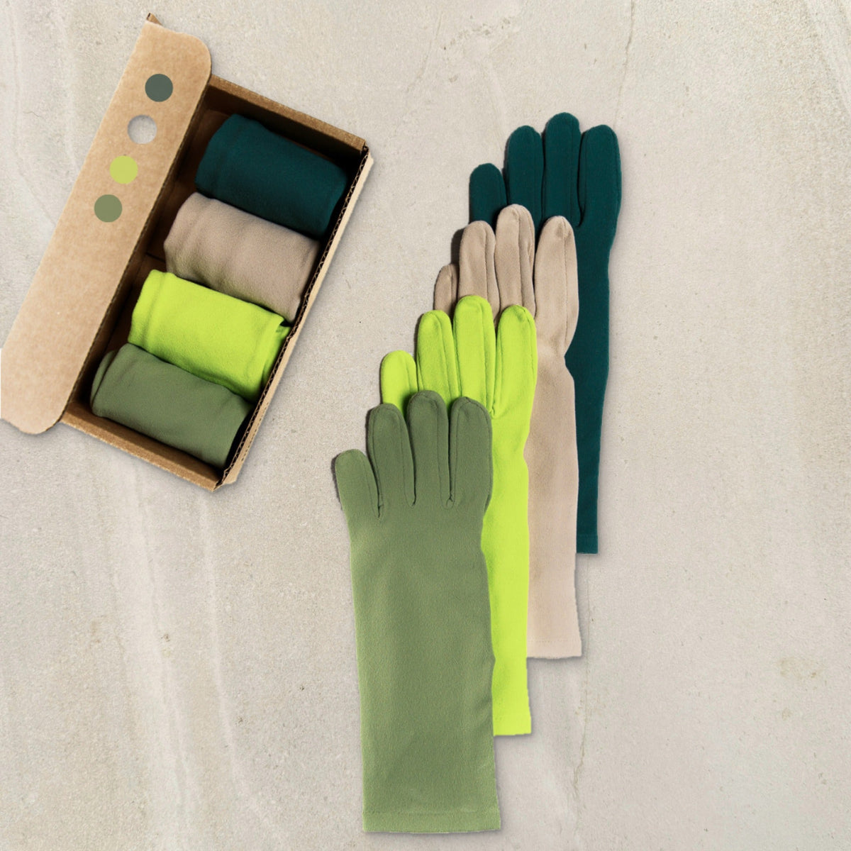 the chronic gardener set: four pairs of higarden gardening gloves in greens and pinenut, rolled in a kraft gift box and fanned out on limestone
