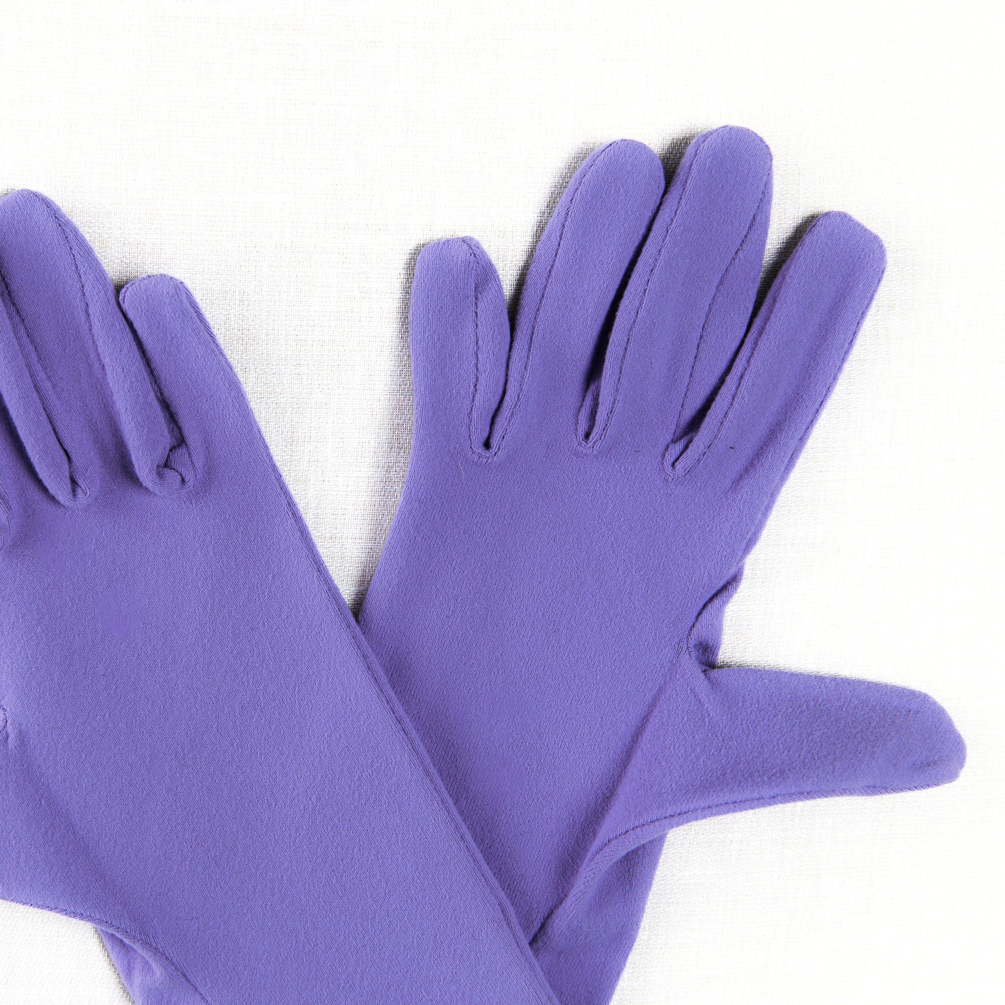 Pair of purple gloves on a white background