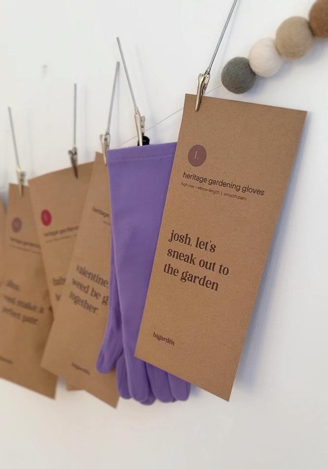 Purple gardening gloves with a brown tag on a white background