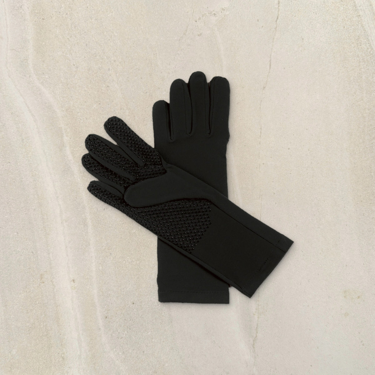 higarden mid rise gardening gloves in black showing the grip palm, flat lay on limestone