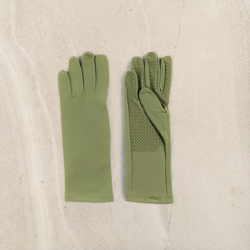 A pair of olive green gloves laid flat on a light beige textured surface. One glove is shown from the back with smooth fabric, and the other is shown from the front with textured grip panels on the back of the fingers and palm.