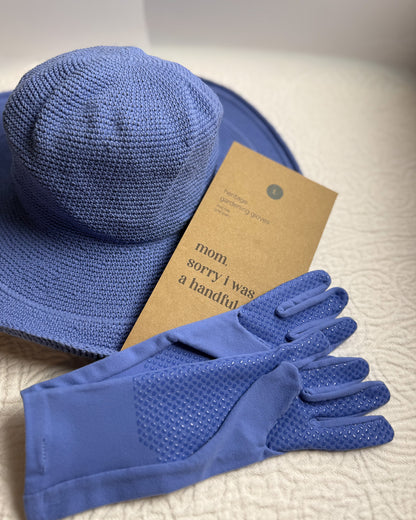 Blue sun hat and matching gloves with kraft packaging on a soft white surface